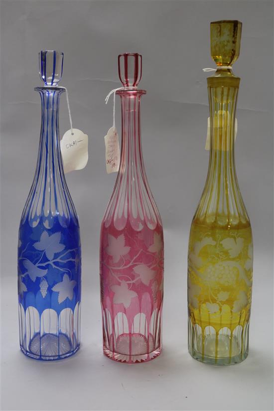 Three Victorian colour overlaid vineous etched glass decanters	